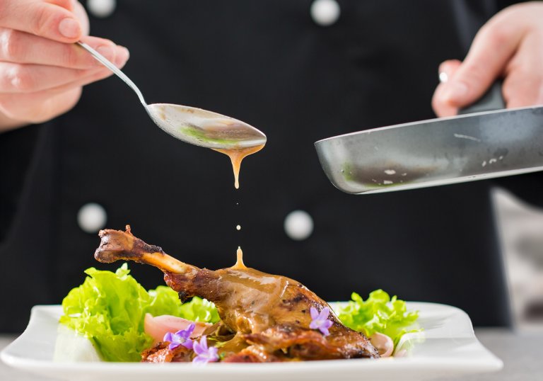 foto saus som helles over en middagsrett